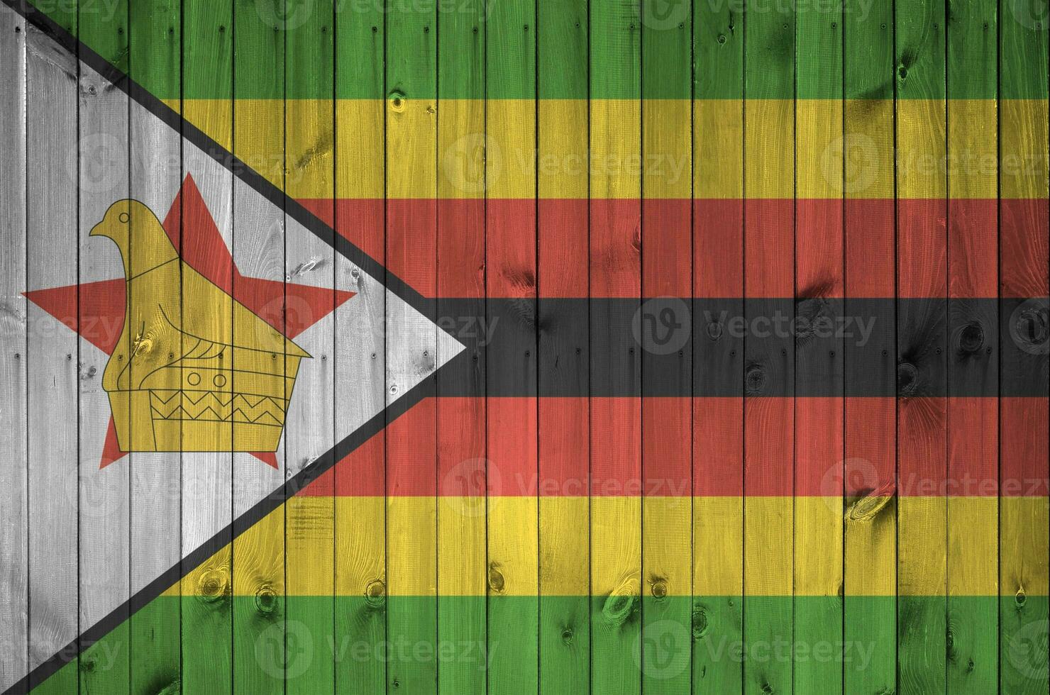 Zimbabwe flag depicted in bright paint colors on old wooden wall. Textured banner on rough background photo