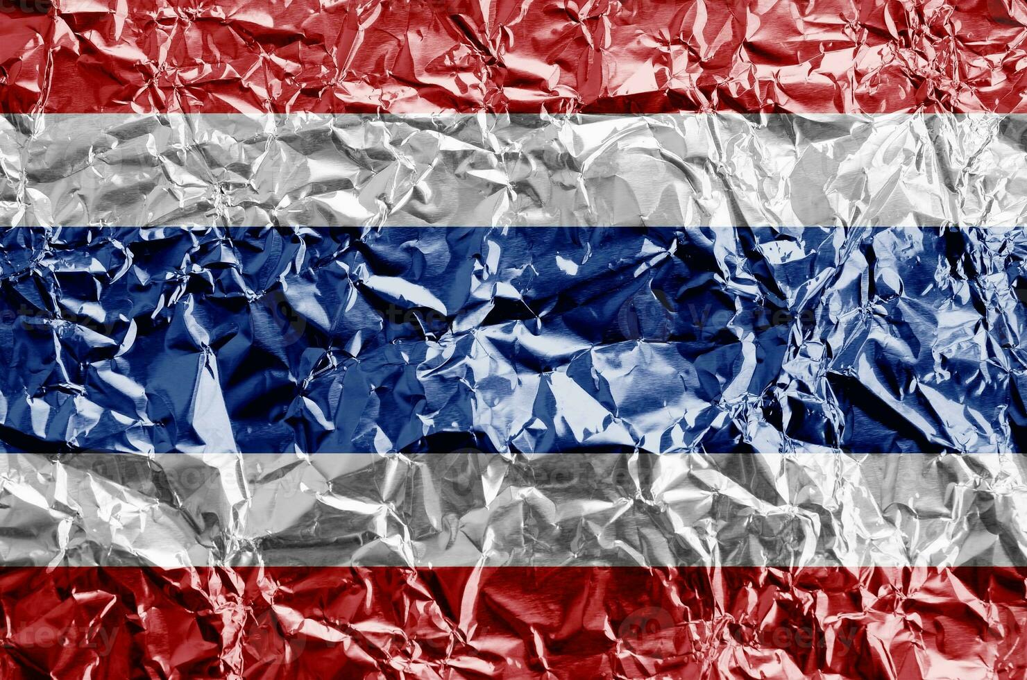 Thailand flag depicted in paint colors on shiny crumpled aluminium foil closeup. Textured banner on rough background photo