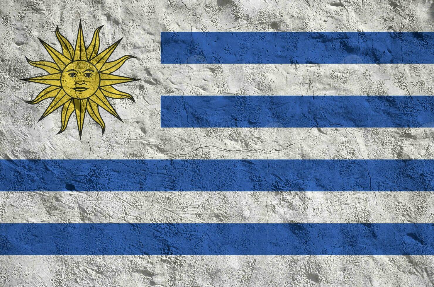 Uruguay flag depicted in bright paint colors on old relief plastering wall. Textured banner on rough background photo