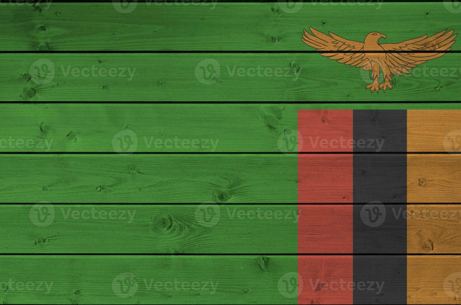 Zambia flag depicted in bright paint colors on old wooden wall. Textured banner on rough background photo