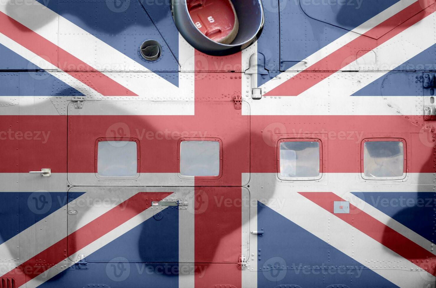 Great britain flag depicted on side part of military armored helicopter closeup. Army forces aircraft conceptual background photo