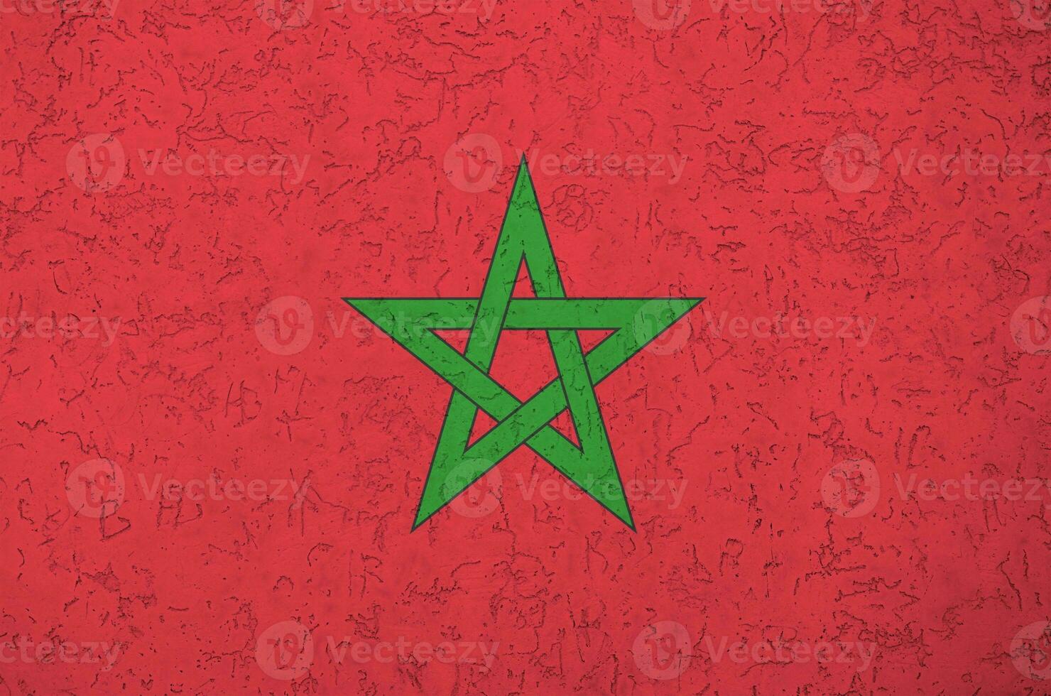 Morocco flag depicted in bright paint colors on old relief plastering wall. Textured banner on rough background photo