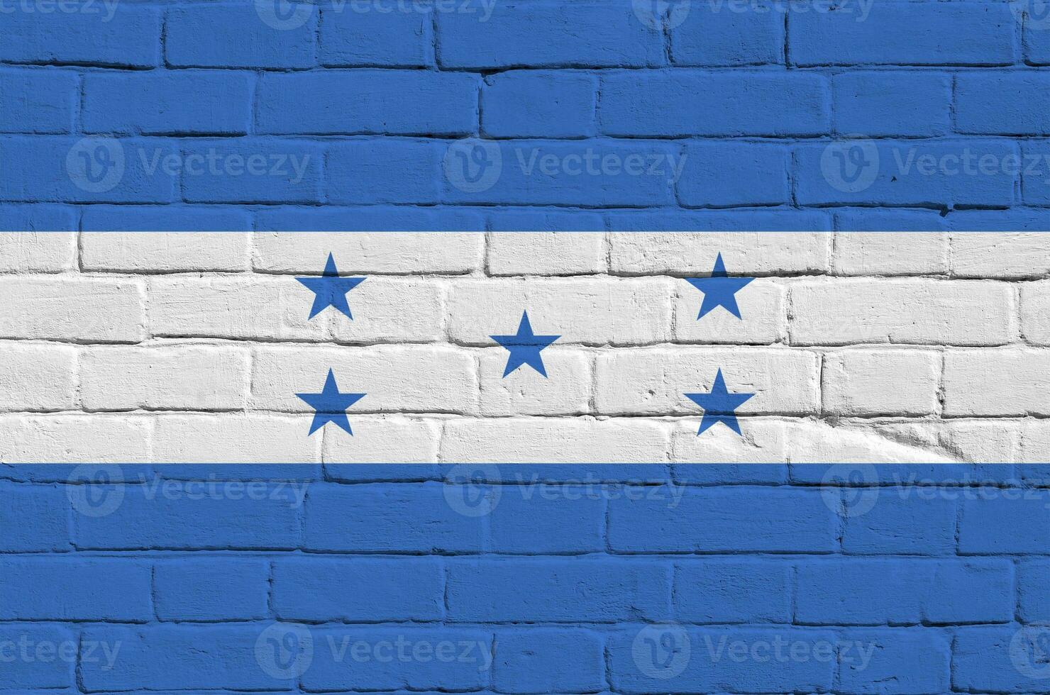 Honduras flag depicted in paint colors on old brick wall. Textured banner on big brick wall masonry background photo
