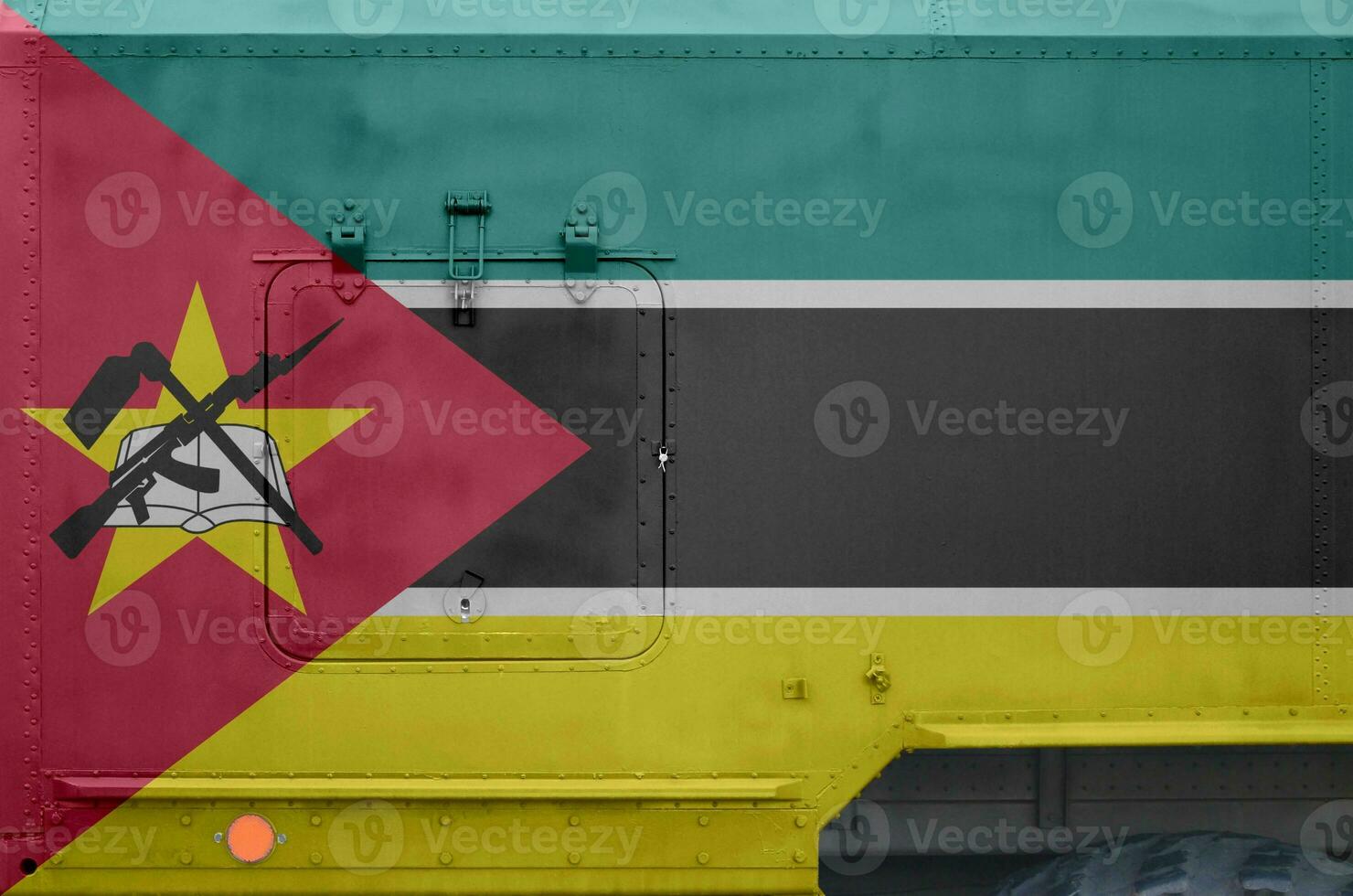 Mozambique flag depicted on side part of military armored truck closeup. Army forces conceptual background photo