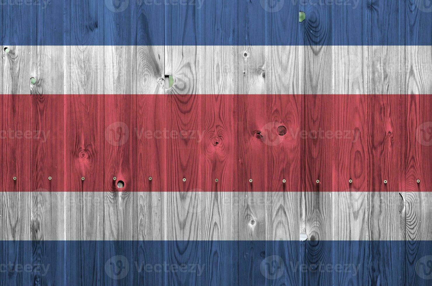 Costa Rica flag depicted in bright paint colors on old wooden wall. Textured banner on rough background photo