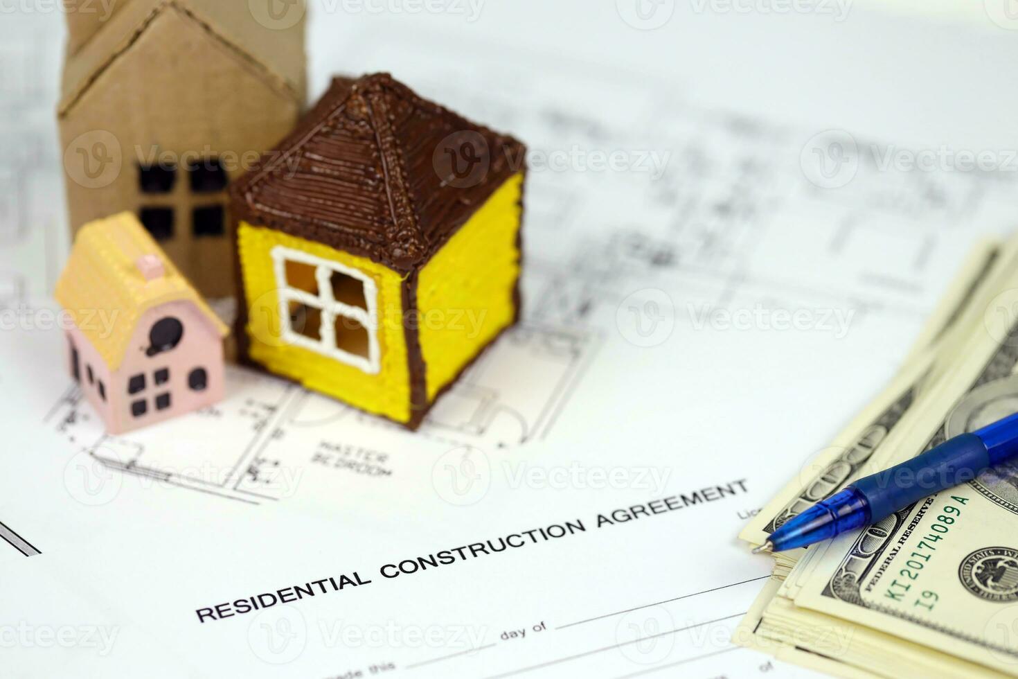Residential construction agreement ready to sign with small toy houses and pen. Construction contract photo