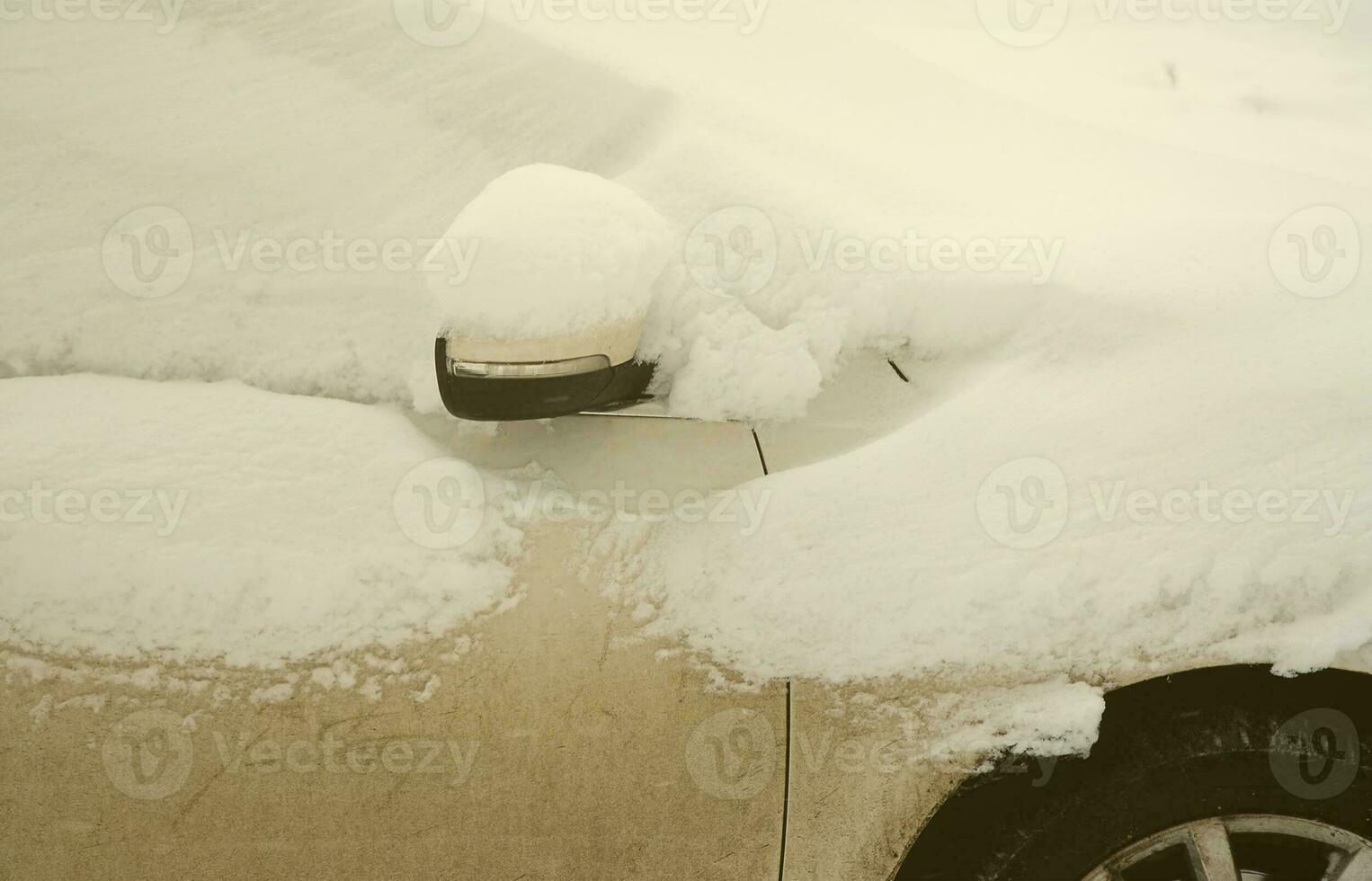 Fragment of the car under a layer of snow after a heavy snowfall. The body of the car is covered with white snow photo