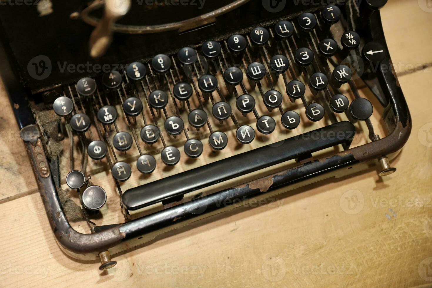 Details of an old retro typewriter in vintage style with dusty surfaces on wooden table photo