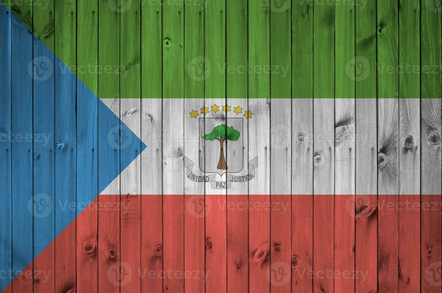 Equatorial Guinea flag depicted in bright paint colors on old wooden wall. Textured banner on rough background photo