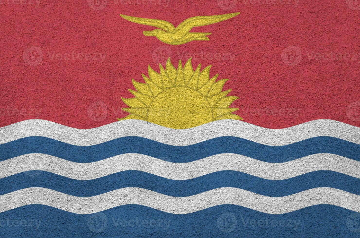 Kiribati flag depicted in bright paint colors on old relief plastering wall. Textured banner on rough background photo