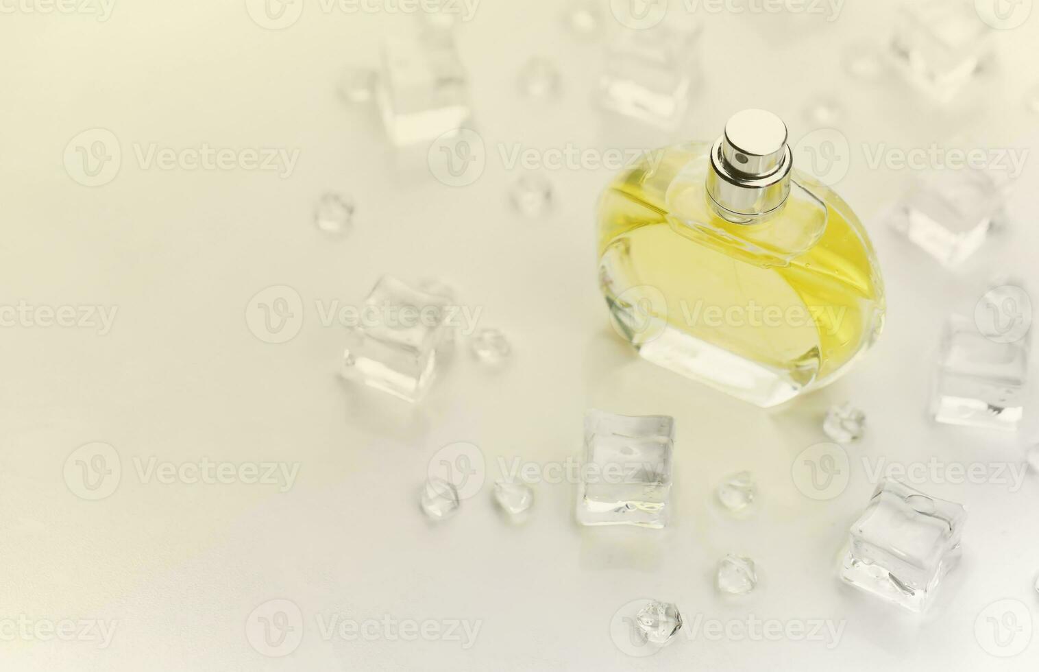 Female perfume yellow bottle, Objective photograph of perfume bottle in ice cubes and water on white table. View from above. Mockup product photo, concept of freshness photo