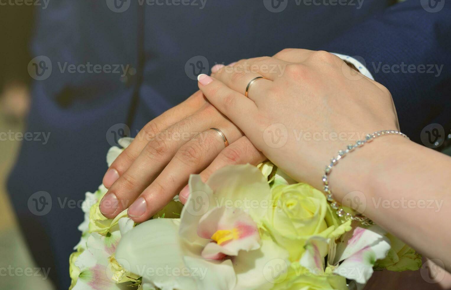 The newlywed couple is holding a beautiful wedding bouquet. Classical wedding photography, symbolizing unity, love and the creation of a new family photo