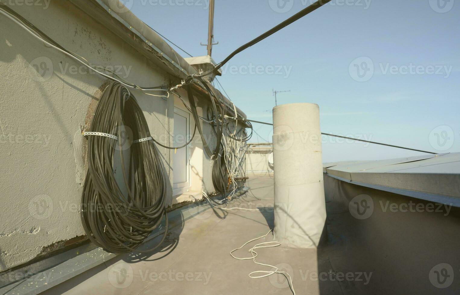 Amplify tv and internet system coaxial cables and fiber optic cable hanging in roll on residental rooftop photo