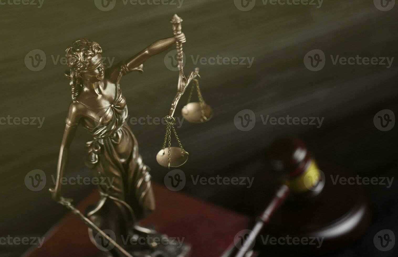 The Statue of Justice - lady justice or justitia the Roman goddess of Justice. Statue on brown book with judge gavel. Concept of judicial trial, courtroom process and lawyers work photo