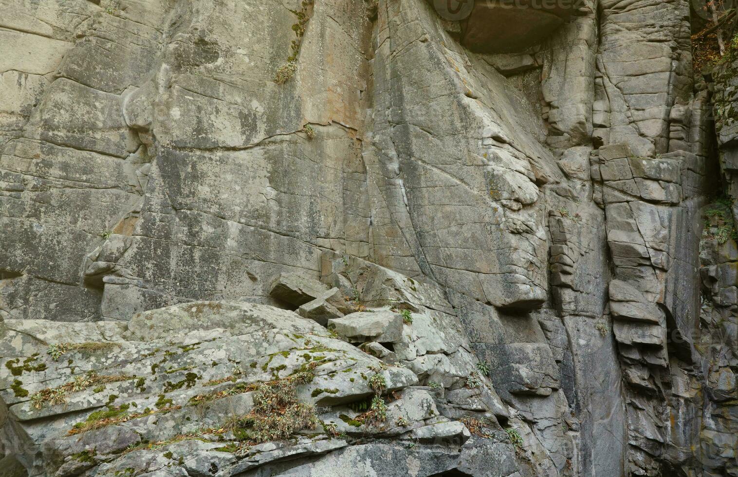 Light coarse natural rock stone background. Mining cliff rough front surface. Big limestone stack backdrop. Heavy grunge damaged granite block texture photo