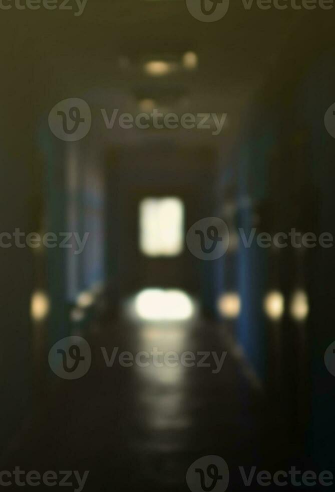 The blurred image of gloomy corridor of a neglected public building. Defocused picture of a public space in a poor residential high-rise building photo