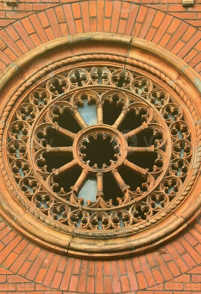 textura frente parte de un antiguo ladrillo cripta con un redondo estampado tallado ventana en el cementerio foto