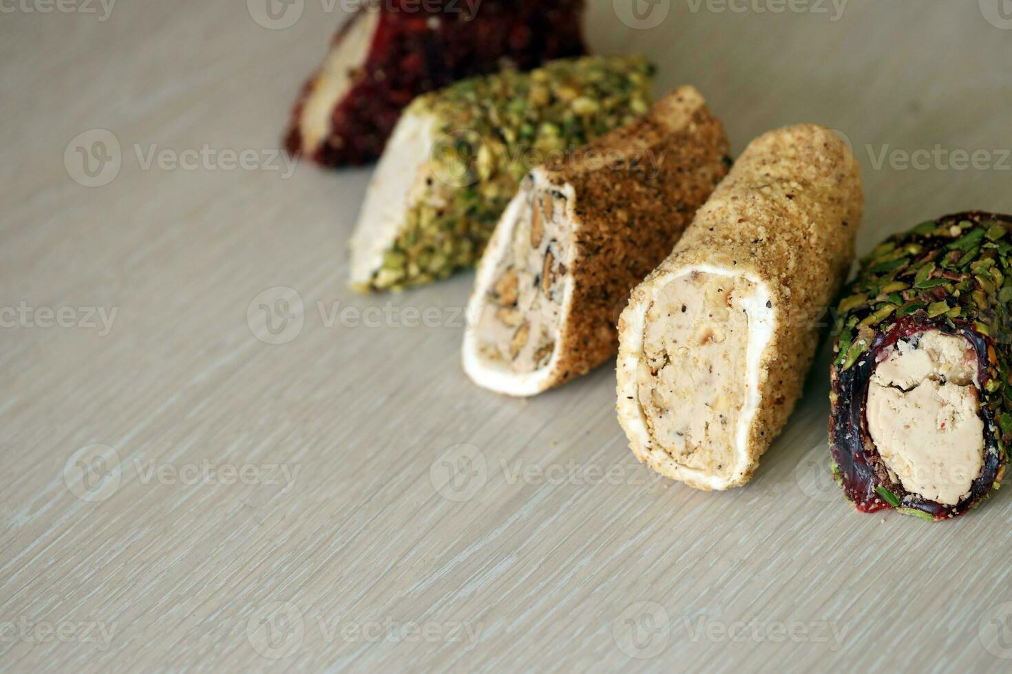 Rolls of turkish delight with many different flavors and fillings close up on table of vendors market with copy space photo