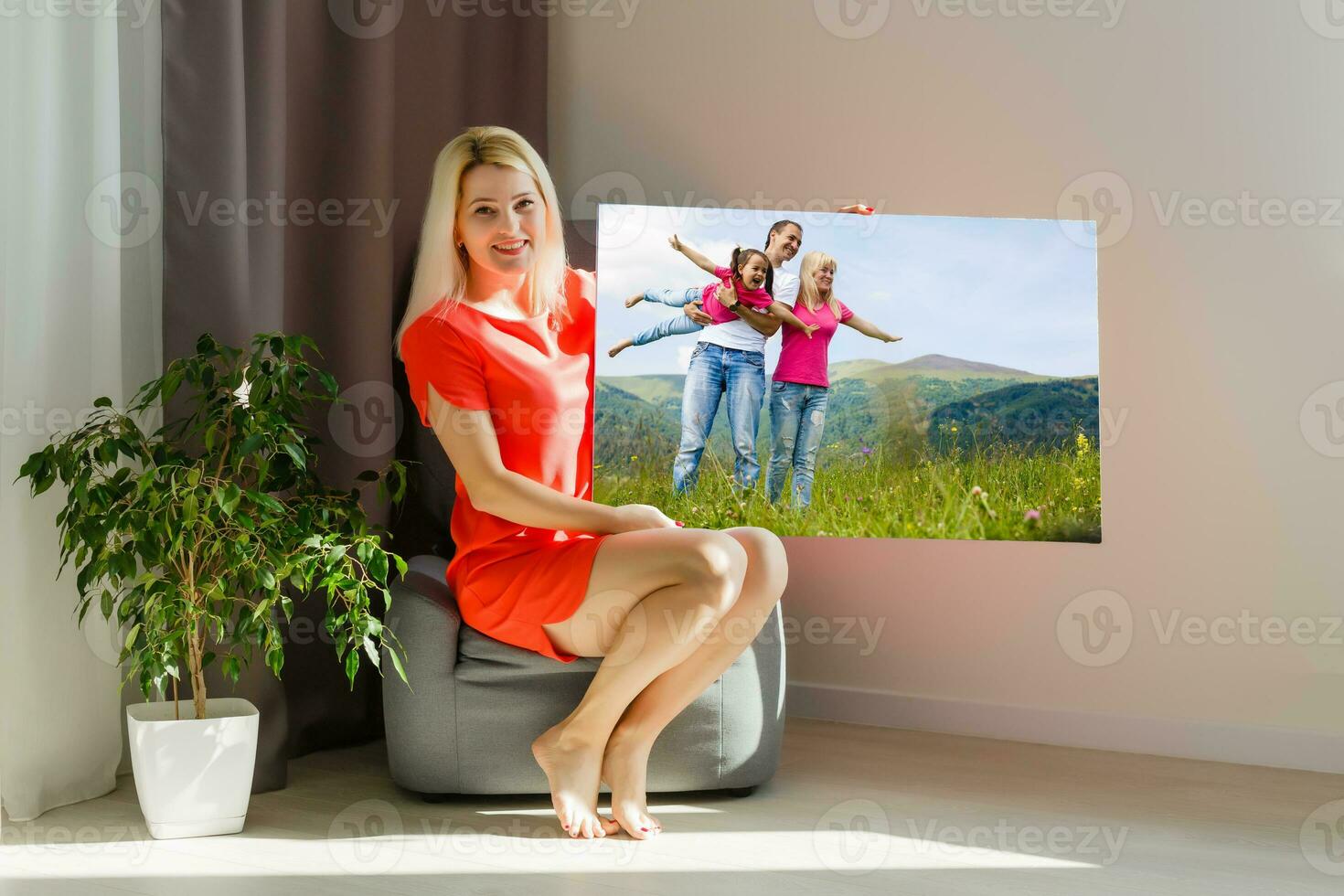 woman holds photo canvas at home