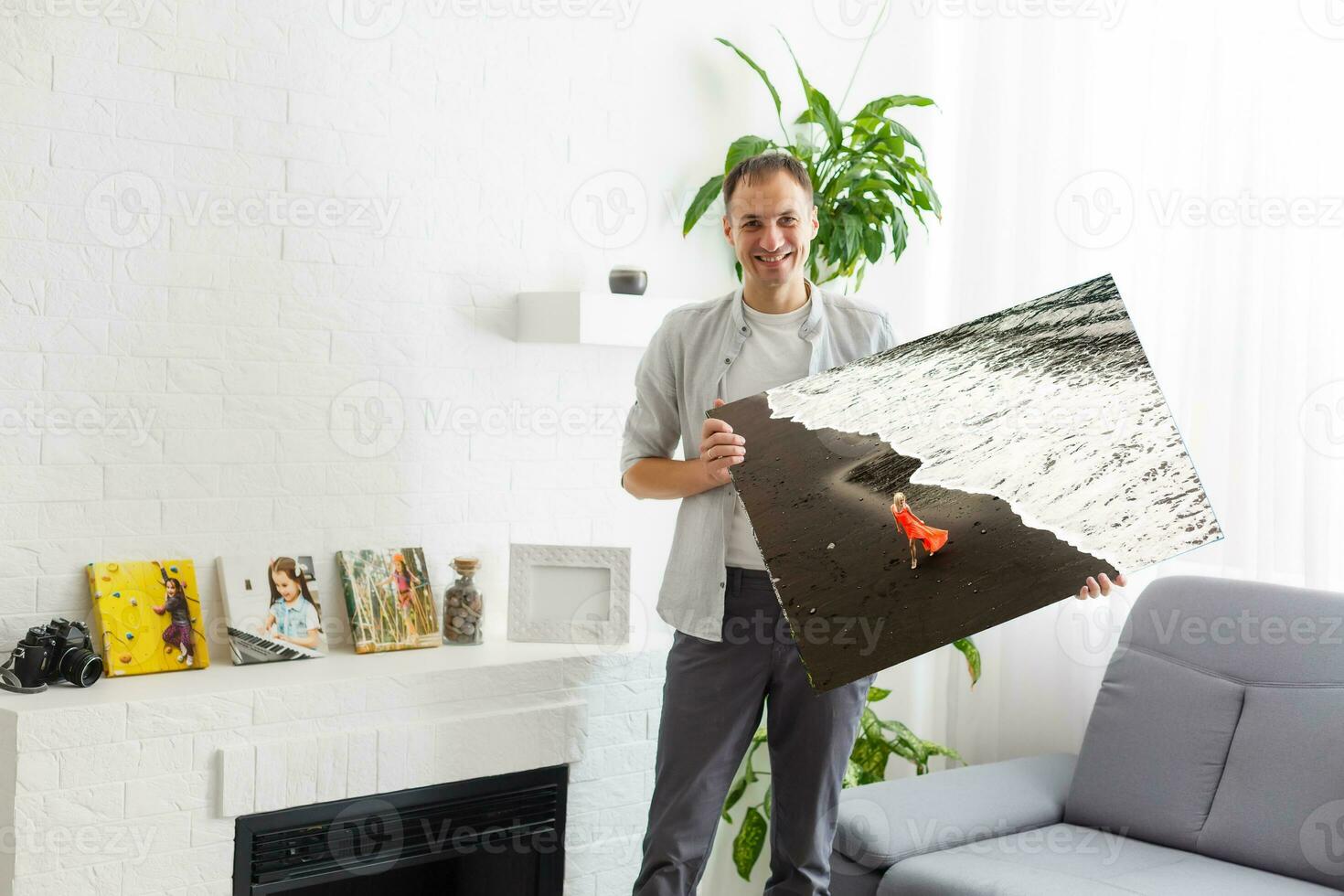 man holds photo canvas at home