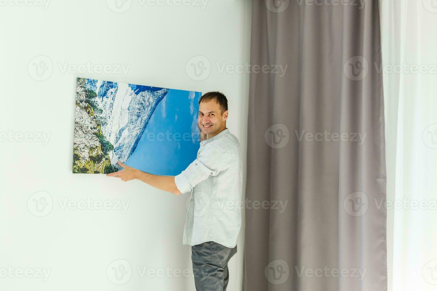 man holds canvas in the interior photo