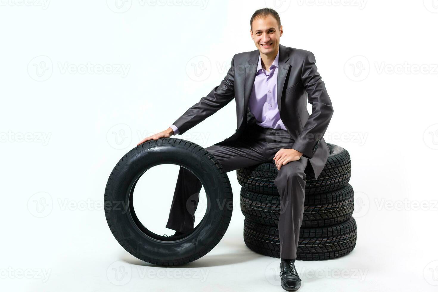 Car dealer man over tire tire background. Auto maintenance. photo