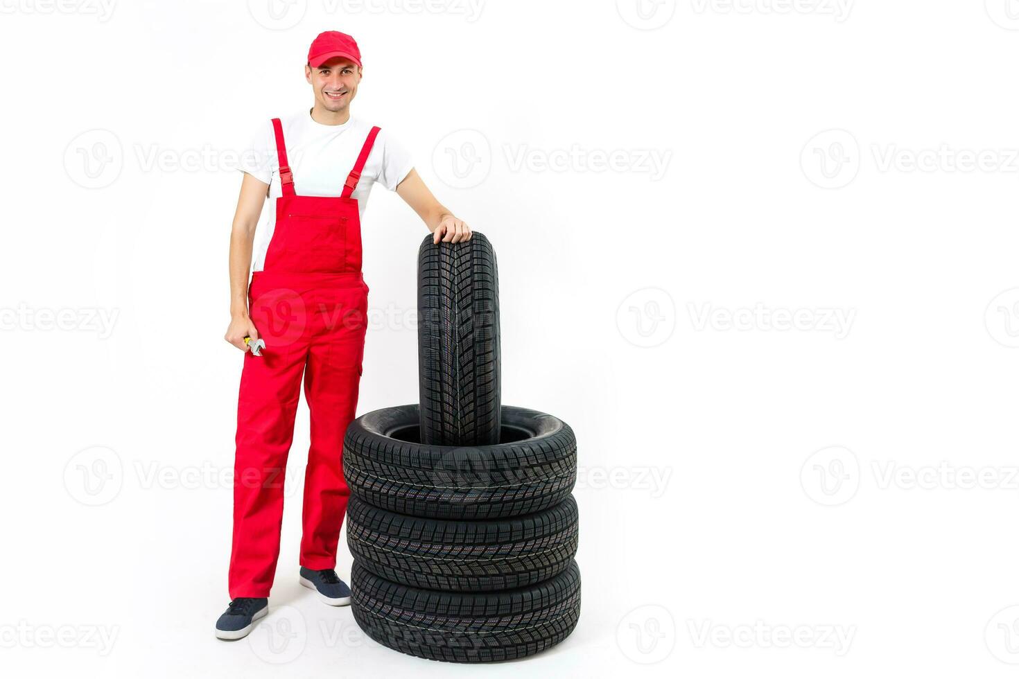 working man in full growth holds a tire on a white background photo