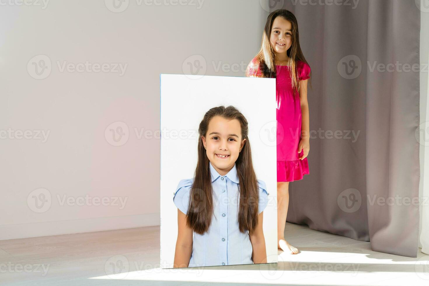 A happy little girl holds canvas at home photo