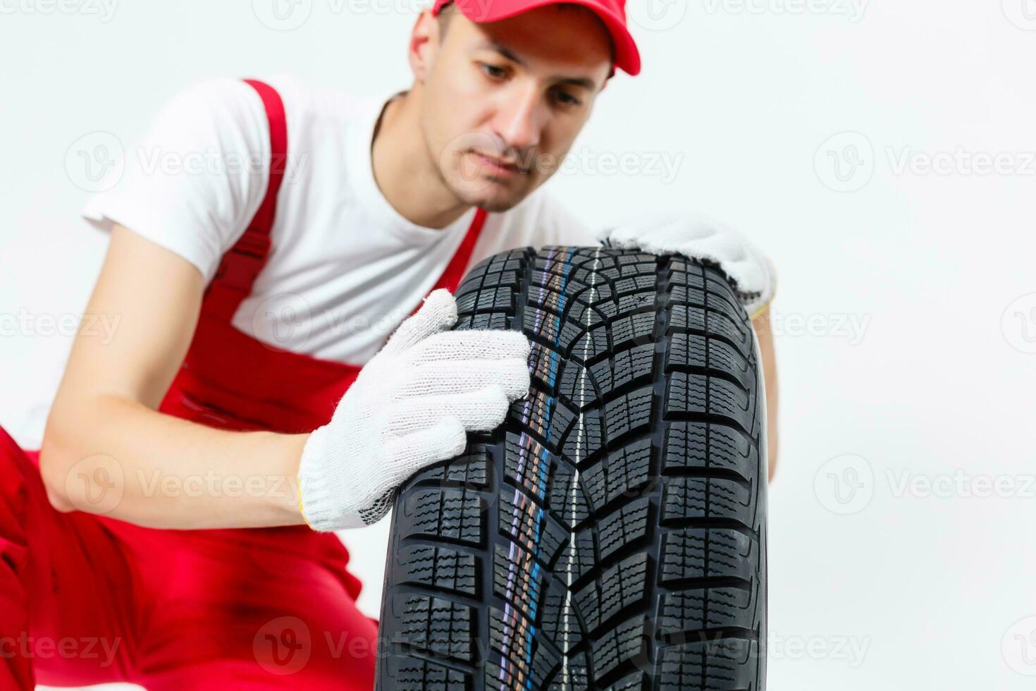 Mechanic Holding Car Tire on a white background photo
