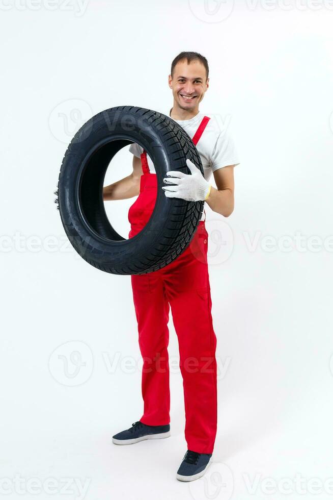 Mechanic holding a tire tire at the repair garage. replacement of winter and summer tires. photo