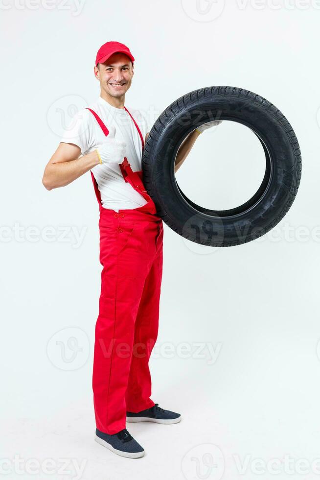 working man in full growth holds a tire on a white background photo