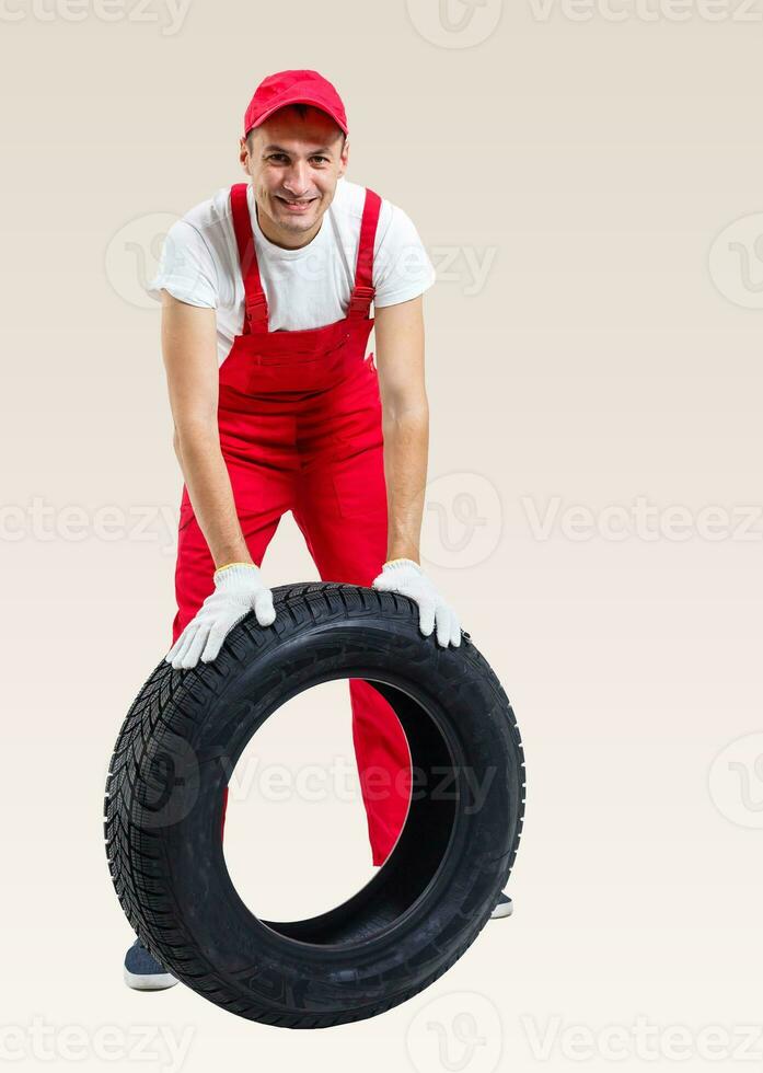 Mechanic holding a tire tire at the repair garage. replacement of winter and summer tires. photo