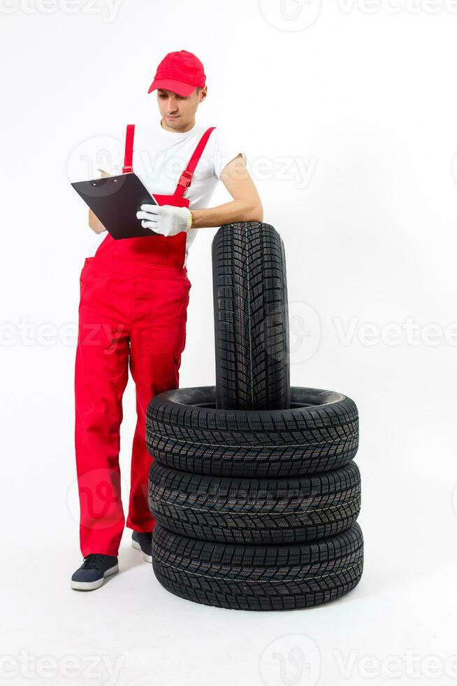 Young mechanic in uniform with a clipboard on white background photo