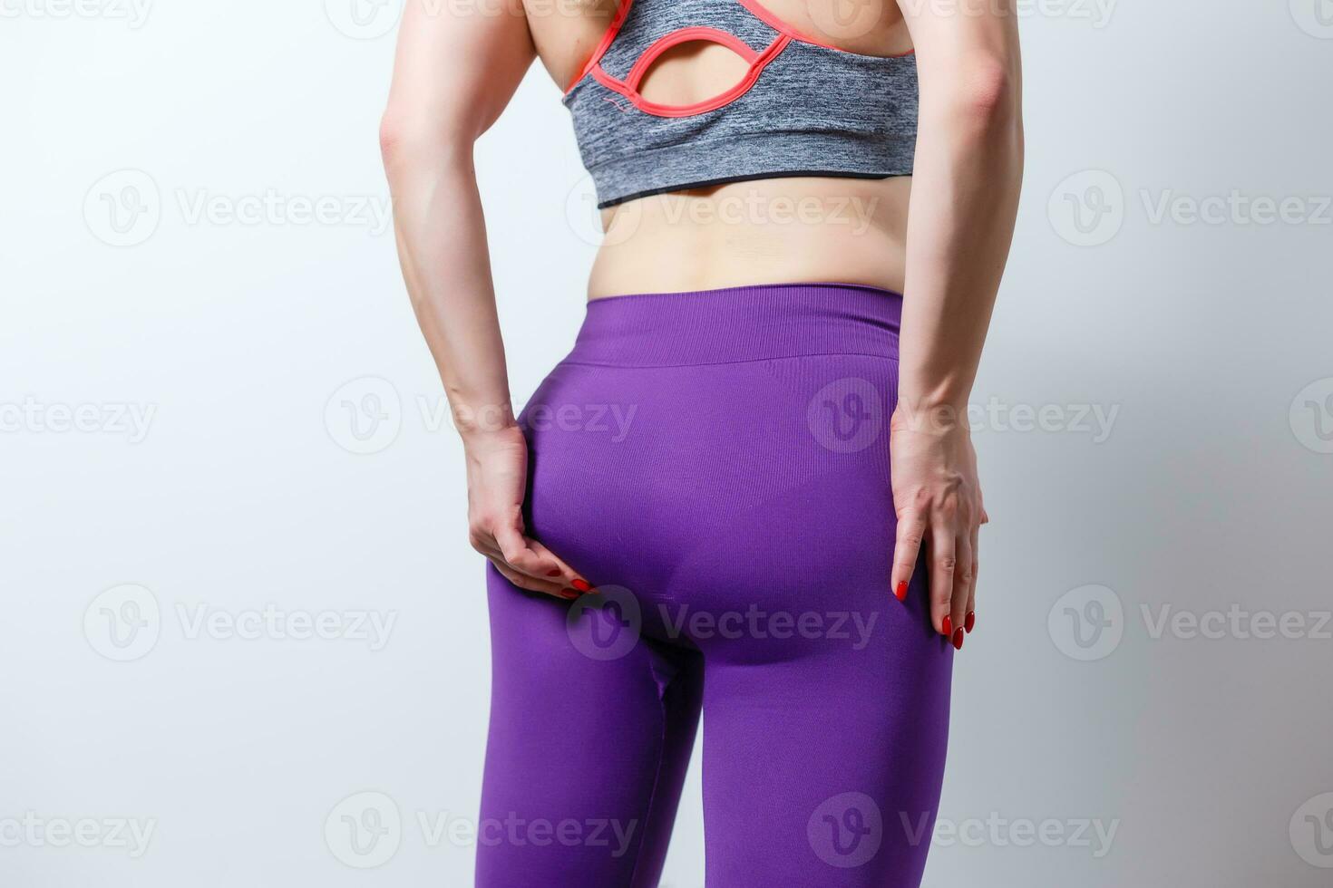 Young Caucasian woman showing her toned and defined back at the gym or a fitness studio after a fat-burning, muscle-defining and stretching workout routine, concept of healthy female body or keep-fit photo