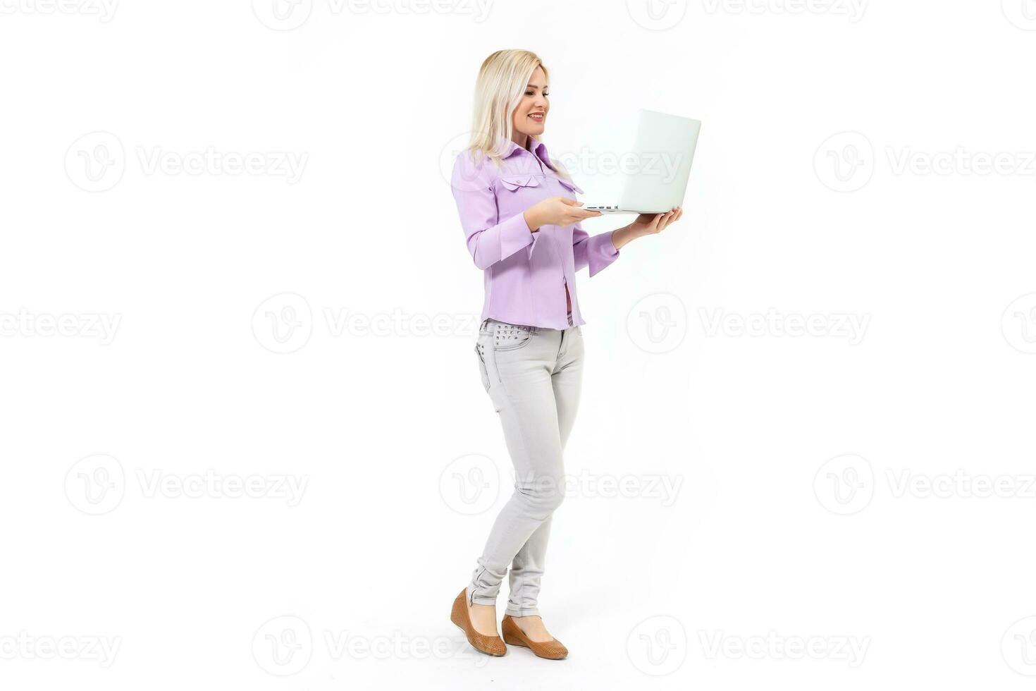 Smiling lovely stylish woman holding laptop computer while standing over white background photo