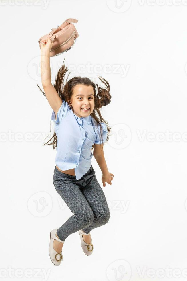 Happy schoolgirl jumping high on white background photo