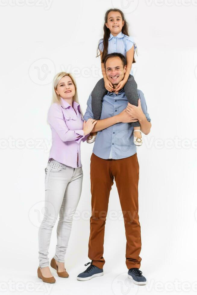 Happy young family with pretty child posing on white background photo