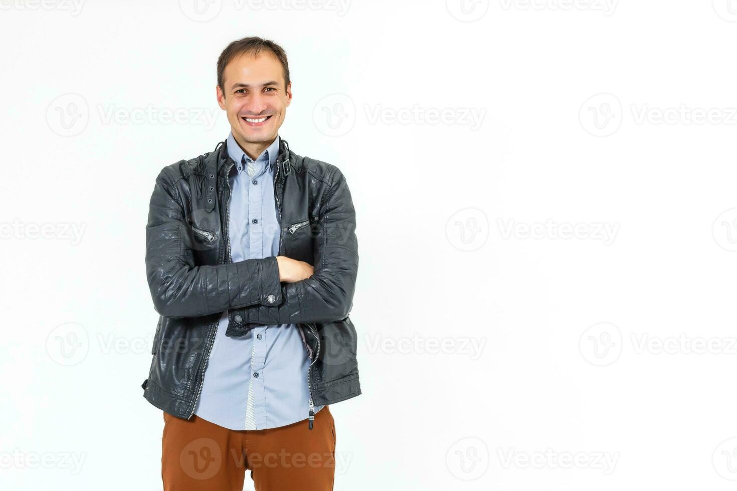 hermoso hombre en cuero chaqueta, pantalones y camisa. terminado blanco antecedentes foto