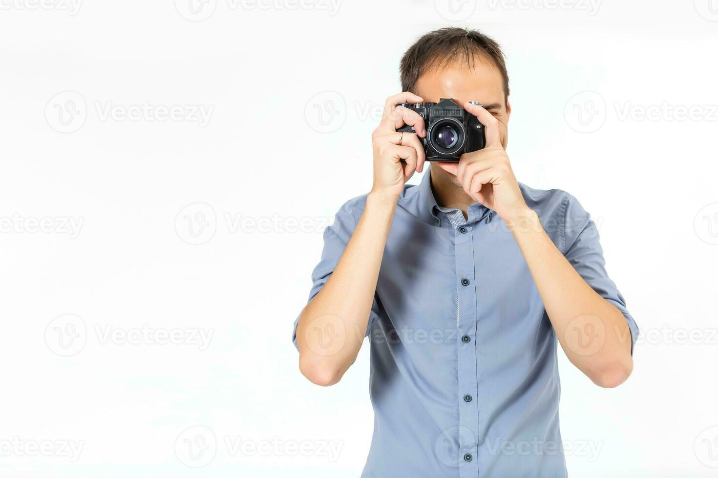 Bend young man taking photo with digital camera side view. isolated over white background.