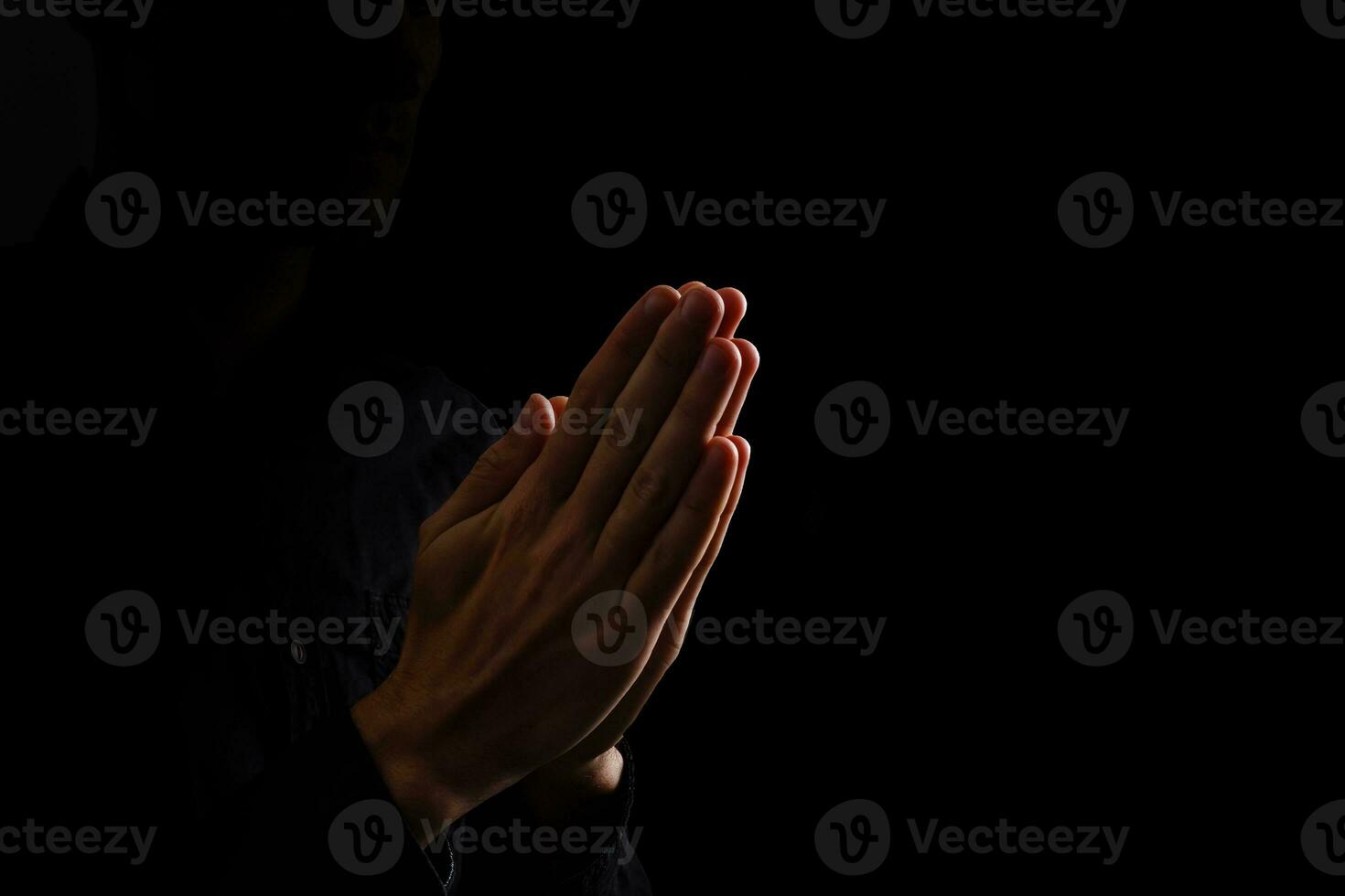 Image of praying hands on a black background photo