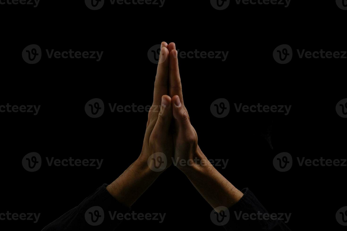 Handsome man sit prayer on black background. His hands are praying for God's blessings. photo