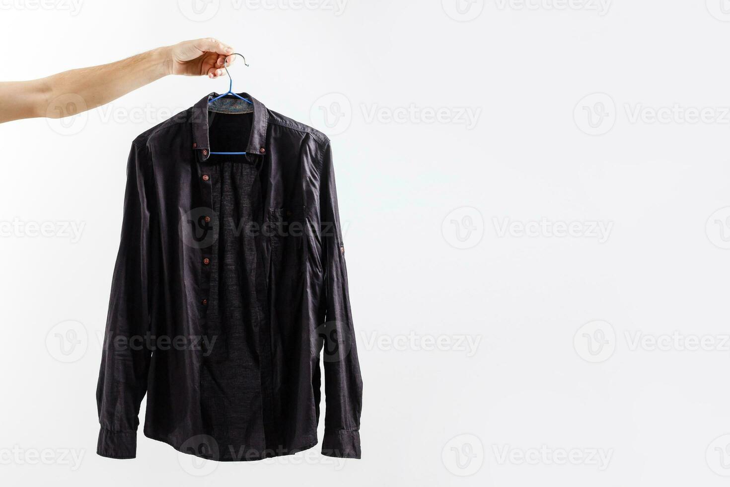 Men's Crew Neck Shirt. Man holding a shirt on a clothes hanger. on a white background photo