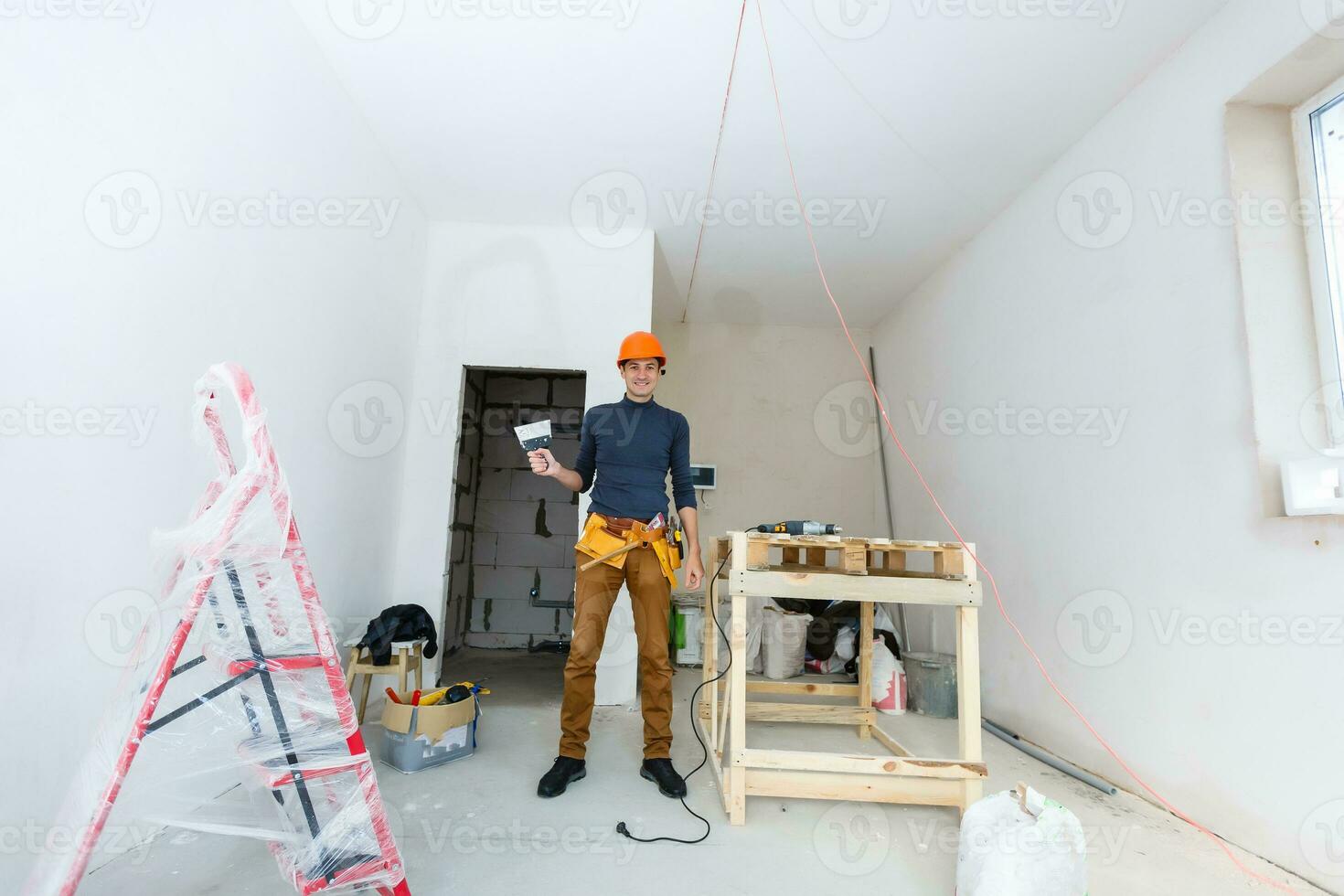 Worker wipes the seams outside the brick house. The builder processes the brickwork. Construction mason worker bricklayer installing red brick with trowel putty knife outdoors. photo