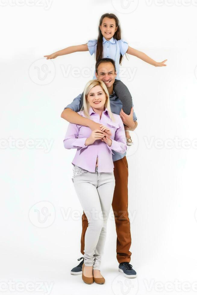 Happy young family with pretty child posing on white background photo