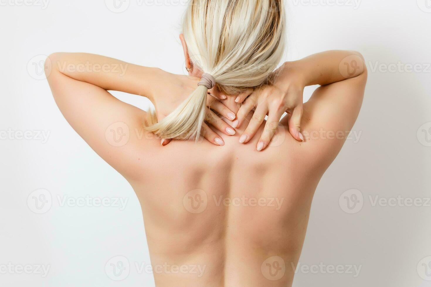 Rear view of a young woman touching her back photo