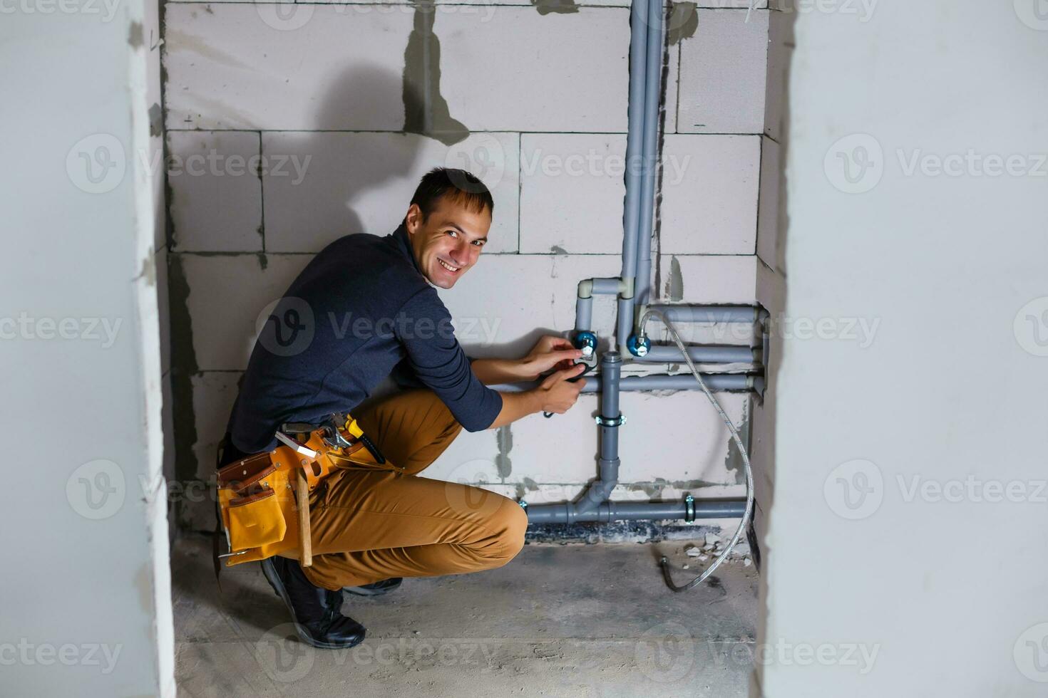 plumber makes wiring of sewer pipes photo