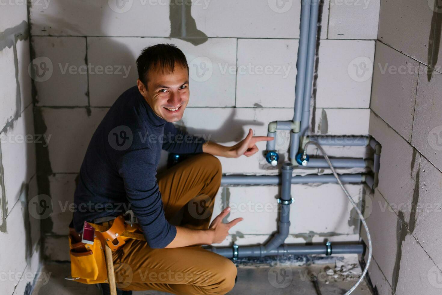 plumber makes wiring of sewer pipes photo
