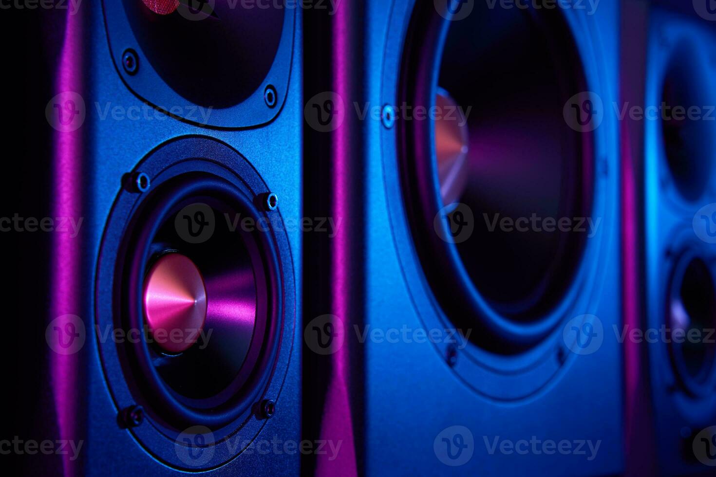 Two sound speakers and subwoofer on dark background with neon lights photo
