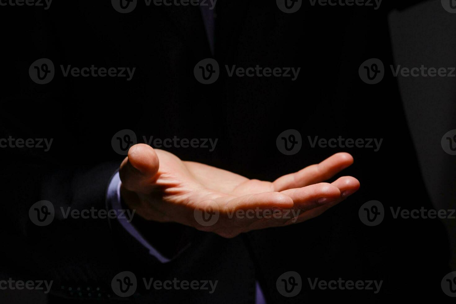 Businessman in blue suit presenting empty palm - it can be used to advertise product on his hands. photo