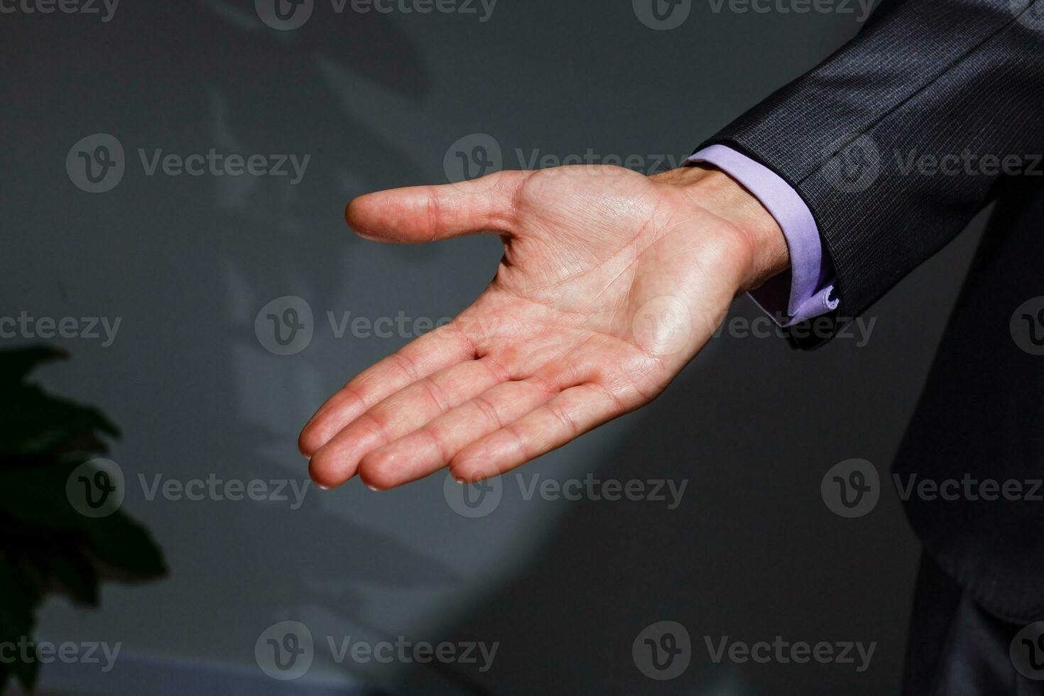 Businessman in blue suit presenting empty palm - it can be used to advertise product on his hands. photo